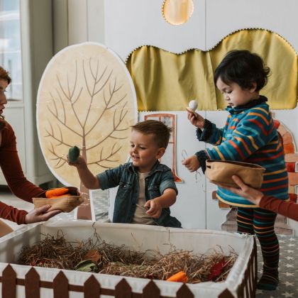 Kinder beim Spielen mit Spiel-Gemüse und Erntekisten in der Spielstadt.